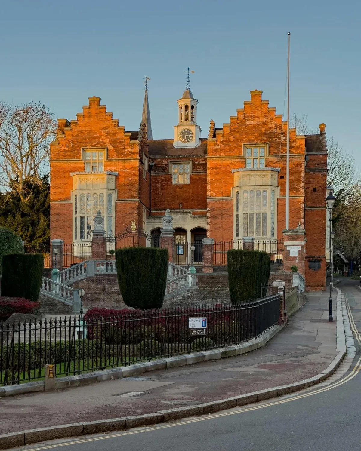 A traditional red-brick British school building at golden hour